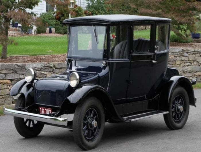 Vintage electric car from the 1800s showing early EV design compared to gasoline cars.